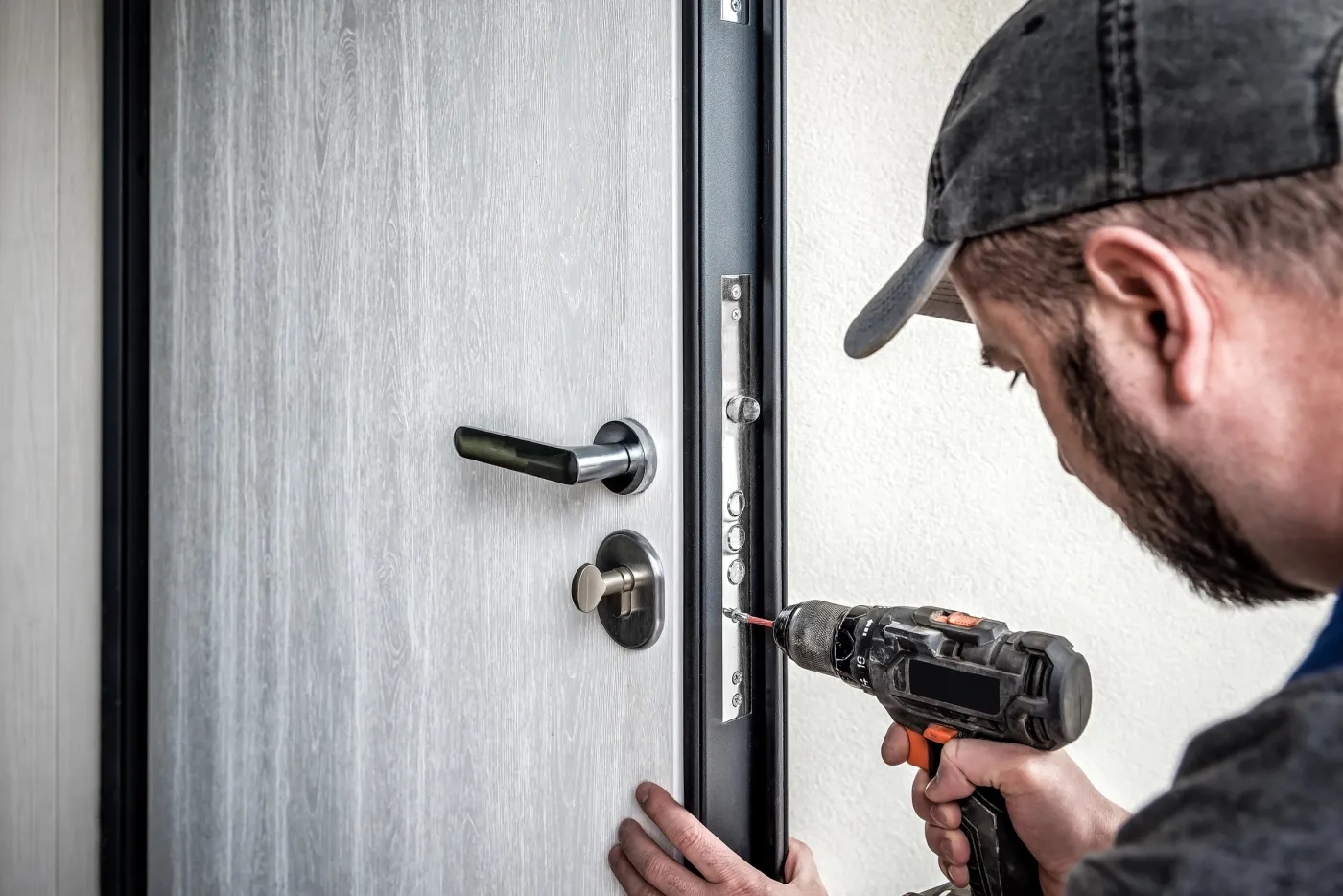 Serrurier de l'atelier posant un blindage sur une porte d'entrée à Sèvres (92310)